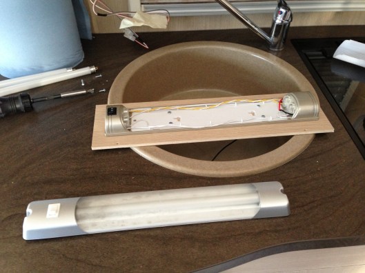 The new fitting screwed to the base panel. The old fitting in front.