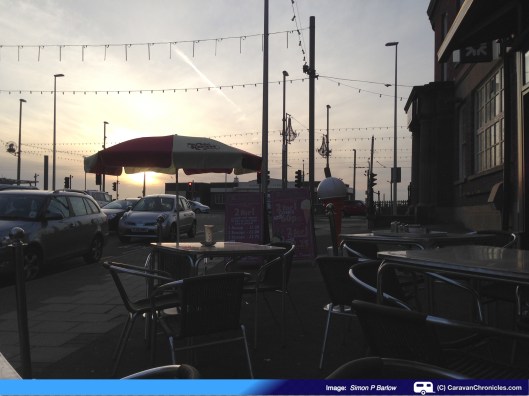 "Setting sun over cafe umbrella"